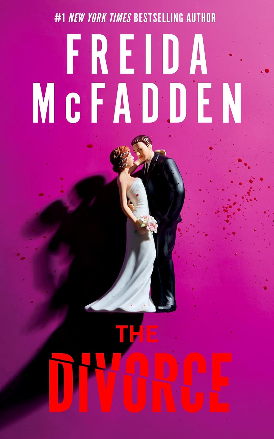 Book cover — The Divorce by Freida McFadden, a wedding cake topper on a pink background